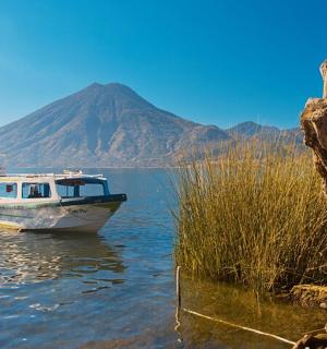 a boat in the water with a mountain in the background