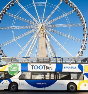 a double decker bus parked in front of a ferris wheel