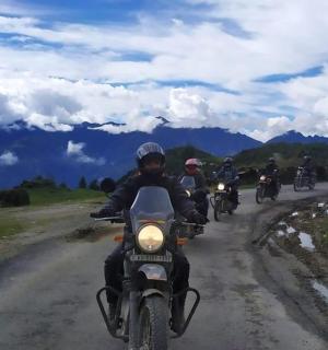 a group of people riding motorcycles down a dirt road