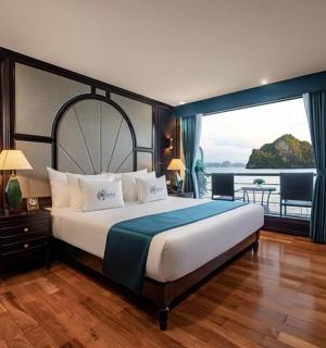 a bedroom with a large bed with a view of the water