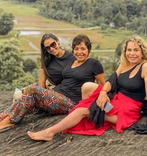 tři ženy sedící na vrcholu skály