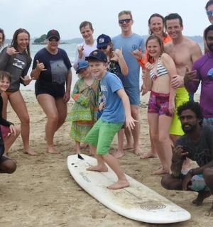 skupina lidí pózujících pro fotku na pláži