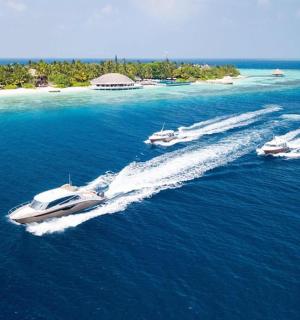 three boats in the water with an island in the background