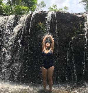 a woman standing in front of a waterfall