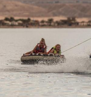 两个女孩在水中乘坐木筏