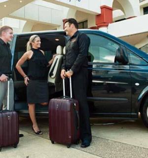 tři lidé stojící před dodávkou se zavazadly