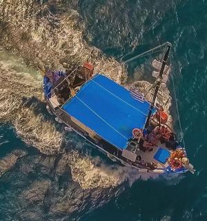 en båd, der flyder i vandet i havet