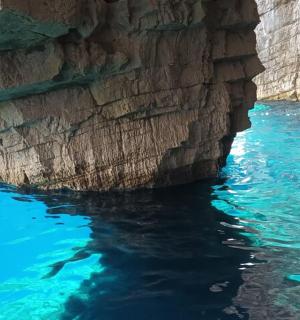 a blue pool of water next to a rocky cliff