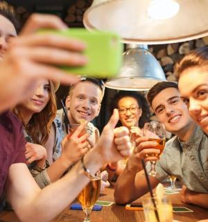 eine Gruppe von Menschen sitzt an einem Tisch und trinkt Wein