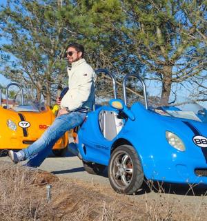 a man and a woman standing next to a toy car