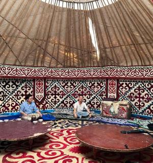 a group of people sitting on a couch in a yurt