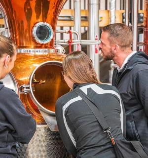 一名男子和两名女子站在桶前