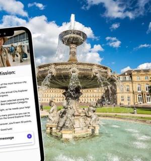 ein Telefon, das ein Foto von einem Brunnen vor einem Gebäude macht