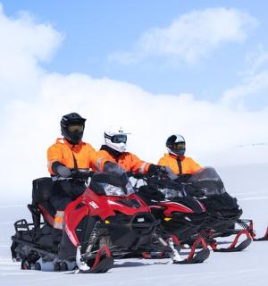 一组三人骑着雪地摩托