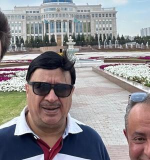 three men standing in front of a large building