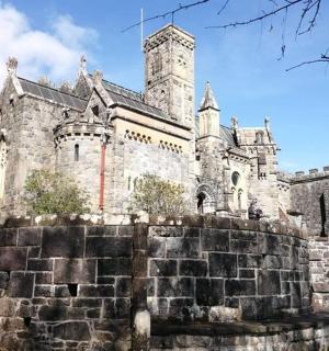 an old castle with a stone wall in front of it