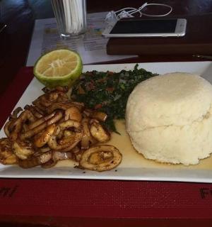 talíř jídla s krevetami, houskou a limetkou