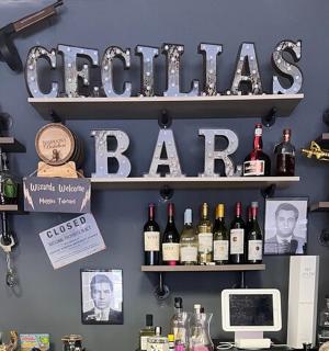 a bar with bottles of wine and a sign that reads cornellias bar