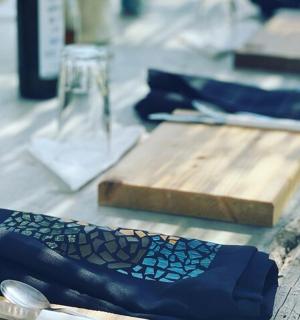 一张摆着蓝色餐巾和木制切菜板的桌子
