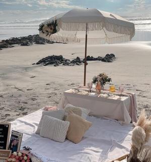 una taula a la platja amb un para-sol