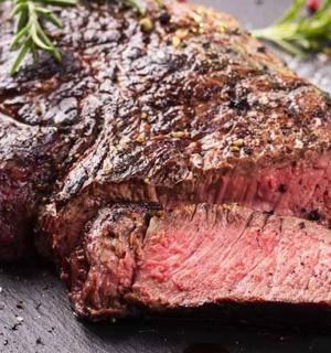 a piece of meat sitting on a black table