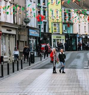 pár lidí jdoucích po ulici s vlajkami