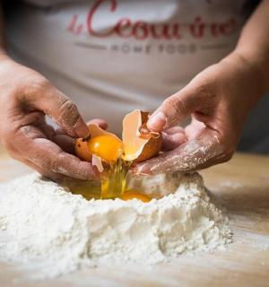 a person cutting an egg into flour on a table