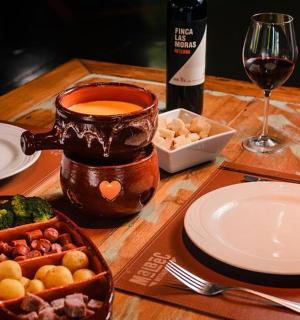 一张木桌上摆着盘子和一瓶酒