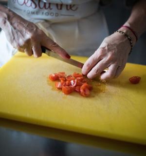 a person cutting up tomatoes on a yellow cutting board
