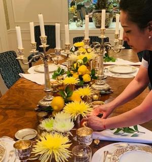 一位女士正在摆放一张摆满鲜花的桌子