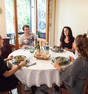 مجموعة من الأشخاص يجلسون حول طاولة ويتناولون الطعام