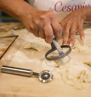 eine Person, die mit einem Messer Lebensmittel auf einem Schneidebrett zerschneidet