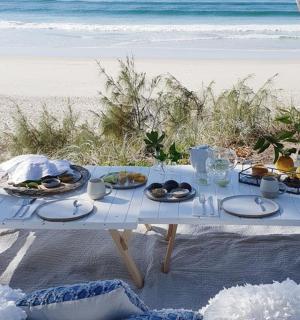 a picnic table with food on the beach