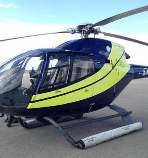 ein blau-gelber Hubschrauber, der auf einer Landebahn geparkt ist