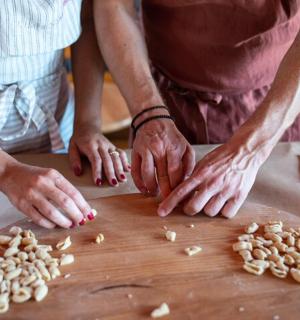 zwei Personen hacken Erdnüsse auf einem hölzernen Schneidebrett