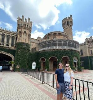 a man and woman standing in front of a castle