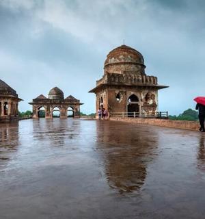 站在建筑物前打着伞的人