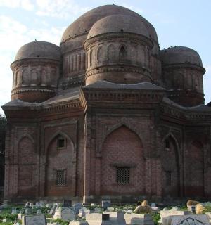 ein großes Gebäude mit einem Friedhof davor