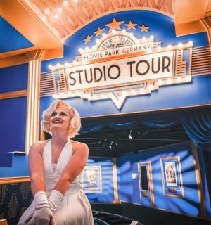 一尊坐在影城参观标志前的女人雕像