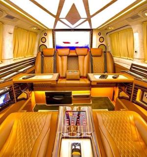 ein Zugraum mit orangefarbenen Sitzen und einem Fernseher