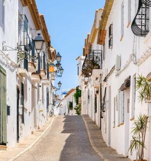 an alley in an old town with white buildings