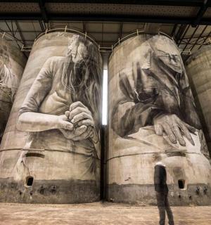 一个人站在一幅画墙前