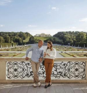 a man and a woman standing on a bridge overlooking a park