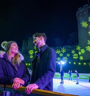 a man and a woman standing in front of an ice rink