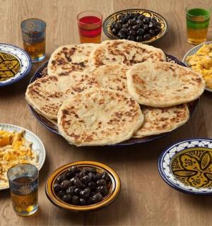 a wooden table topped with plates of food and drinks