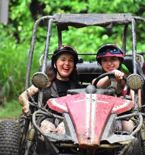 two young girls riding in a toy vehicle