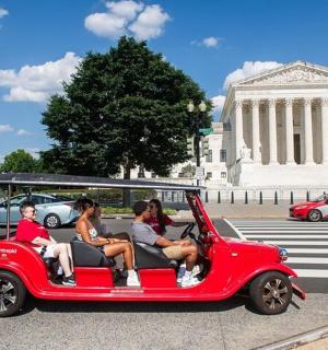 skupina lidí jedoucích v červeném autě
