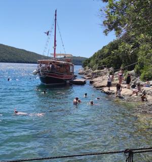 eine Gruppe von Menschen, die im Wasser in der Nähe eines Bootes schwimmen