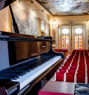 一架钢琴放在一个有红色椅子的房间里