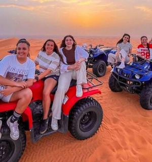 一群妇女坐在沙漠中的四轮摩托车上